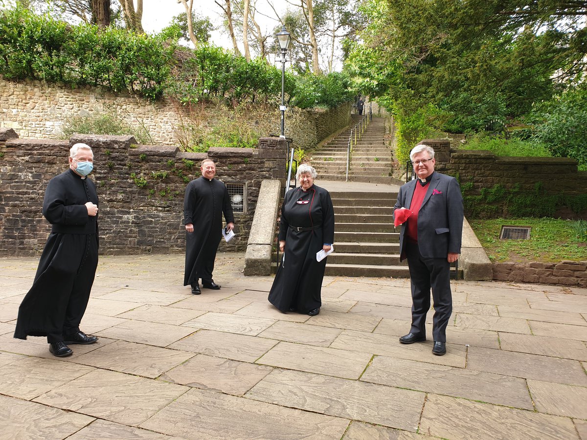 Four socially-distanced clergy outside of Llandaff Cathedral