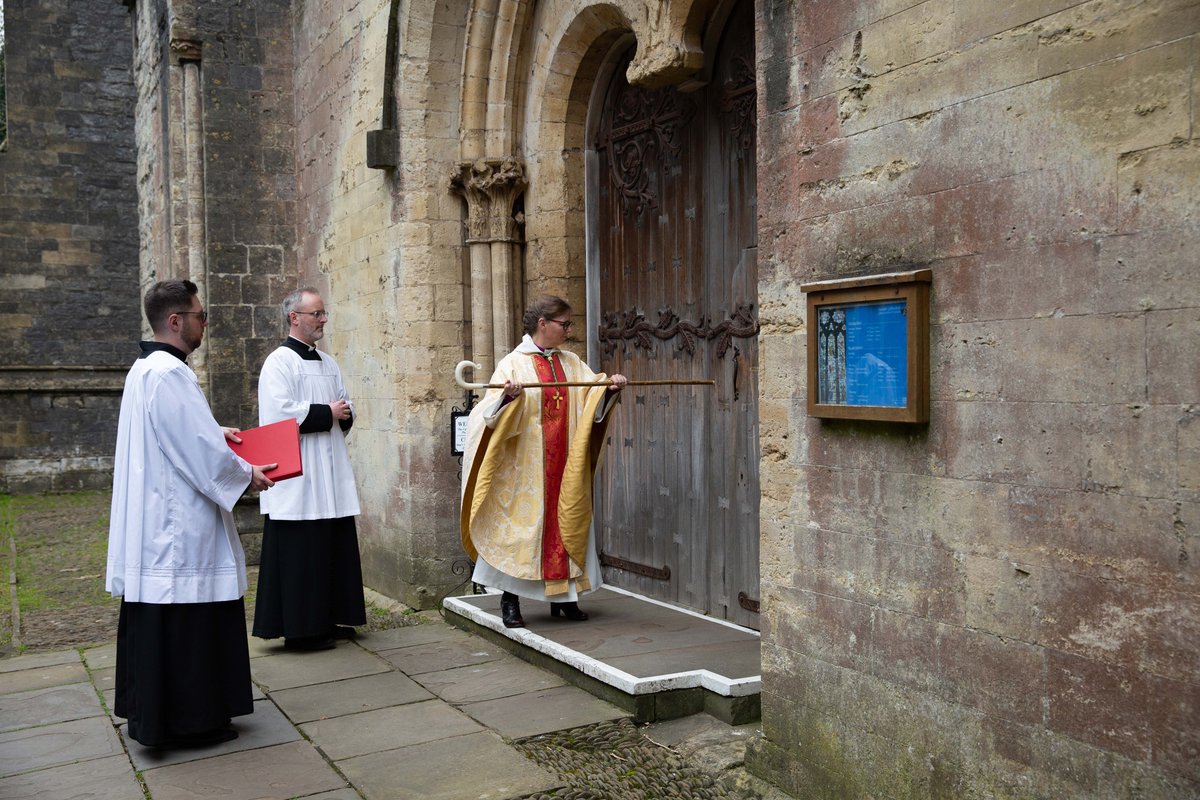Bishop Mary knocks three times with her staff on the large wooden Cathedral Door