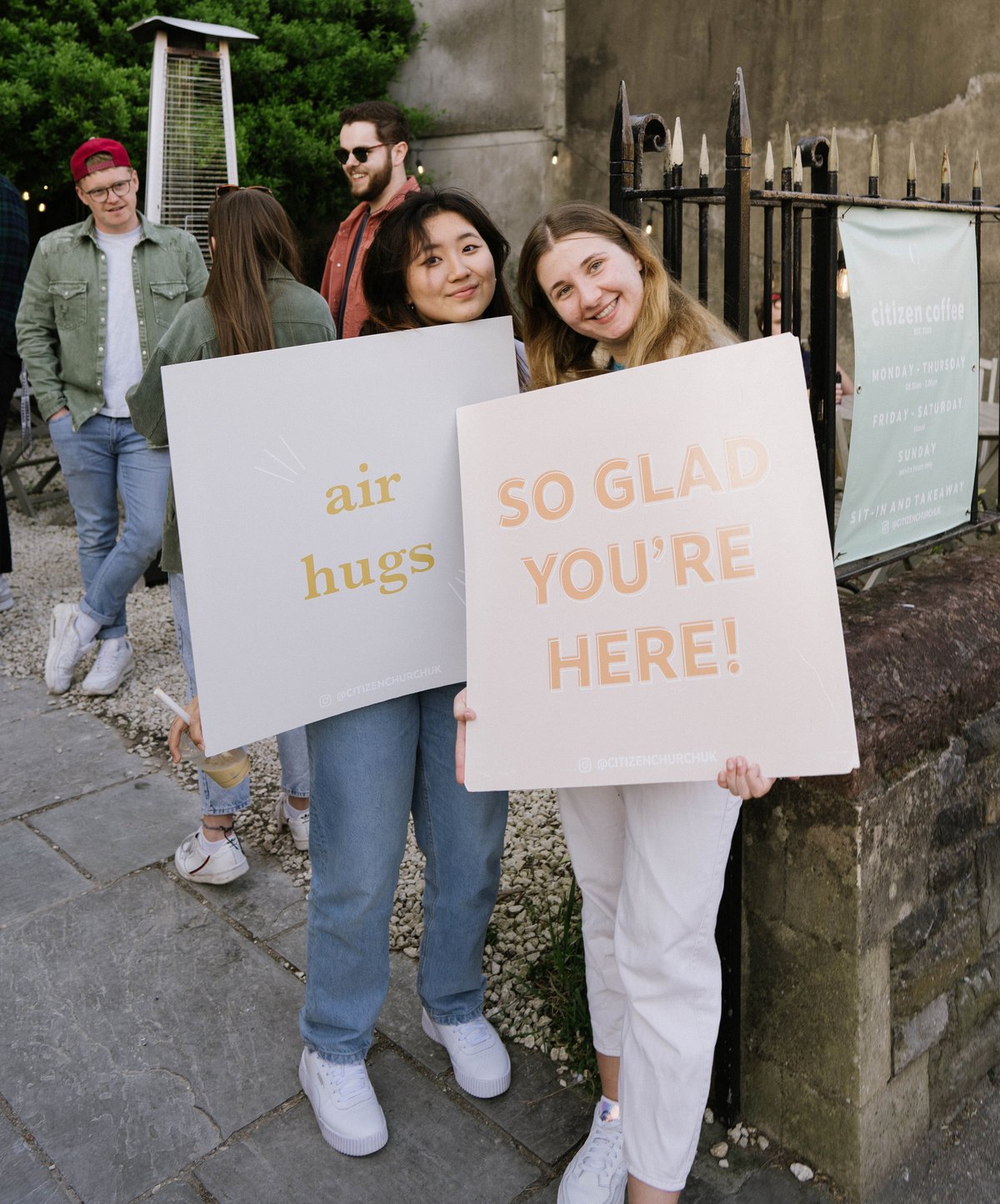 Two women welcoming people to church