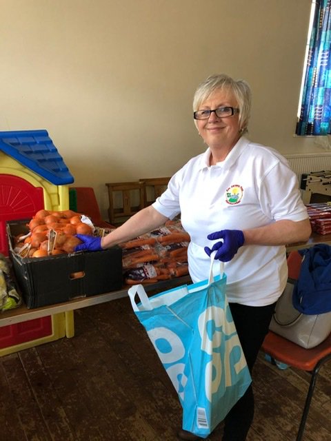 Volunteer sorting through food to give away