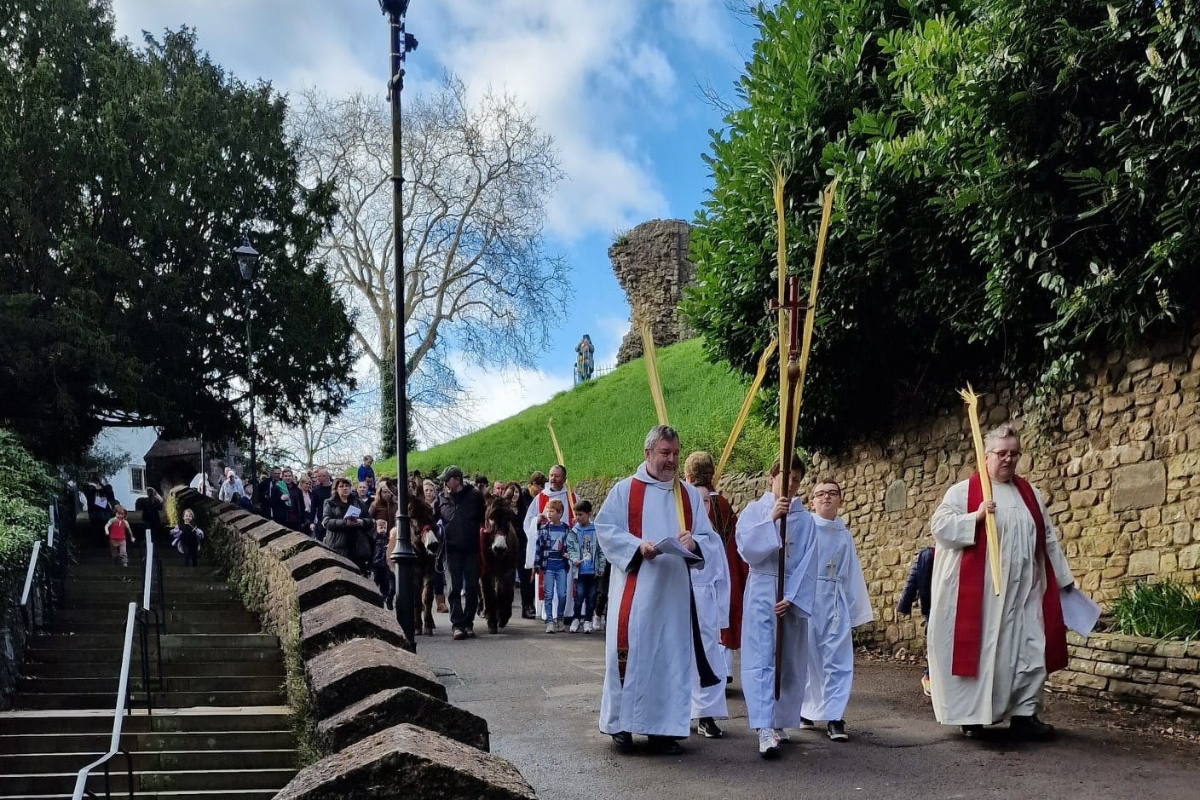 Precentor Mark Preexe and guest Bishop of Liverpool lead procession including two donkeys down the hill outside Llandaff Cathedral on Palm Sunday