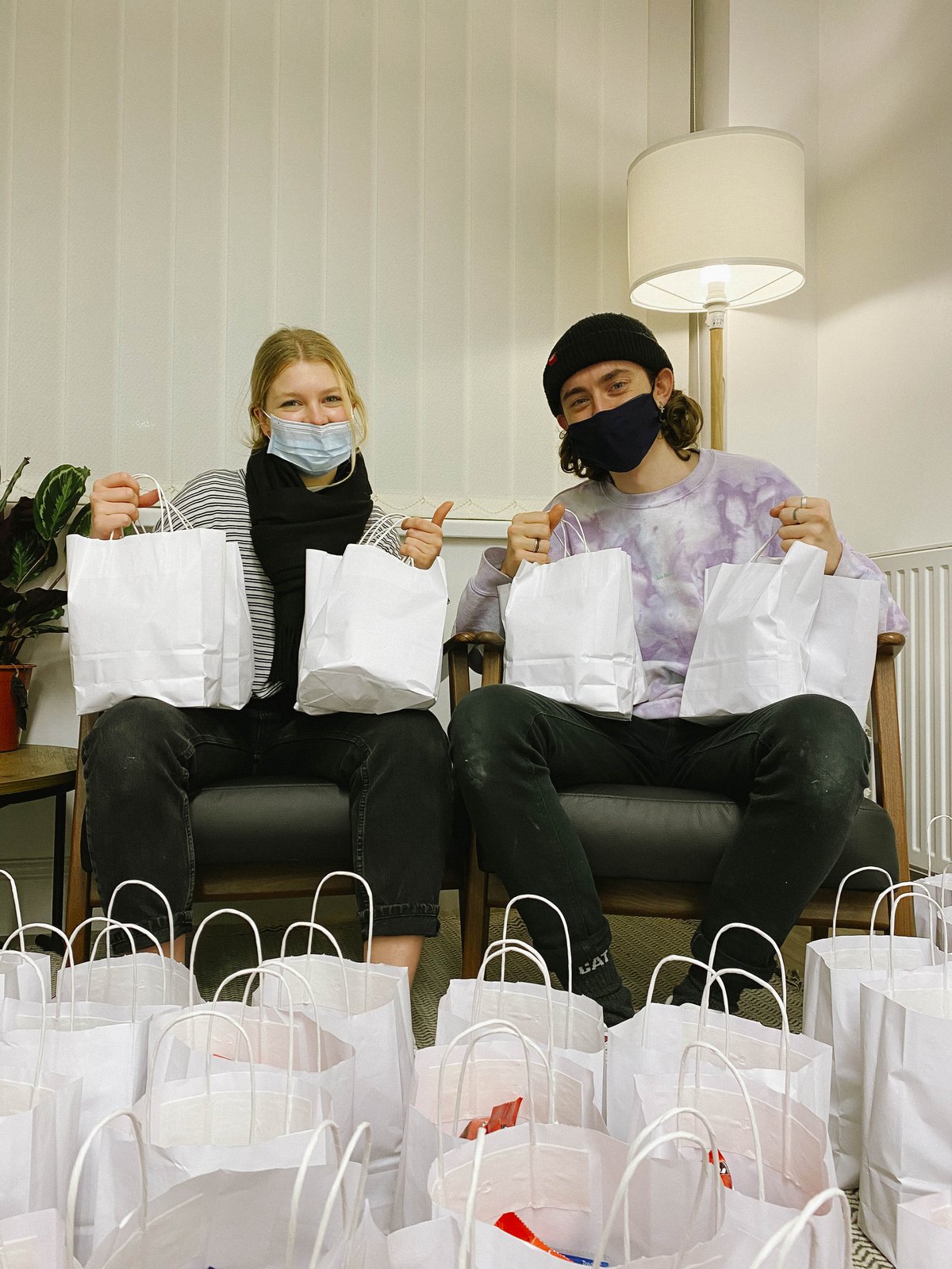 Volunteers Lydia and Dan holding their bags of joy to be sent out to those in need