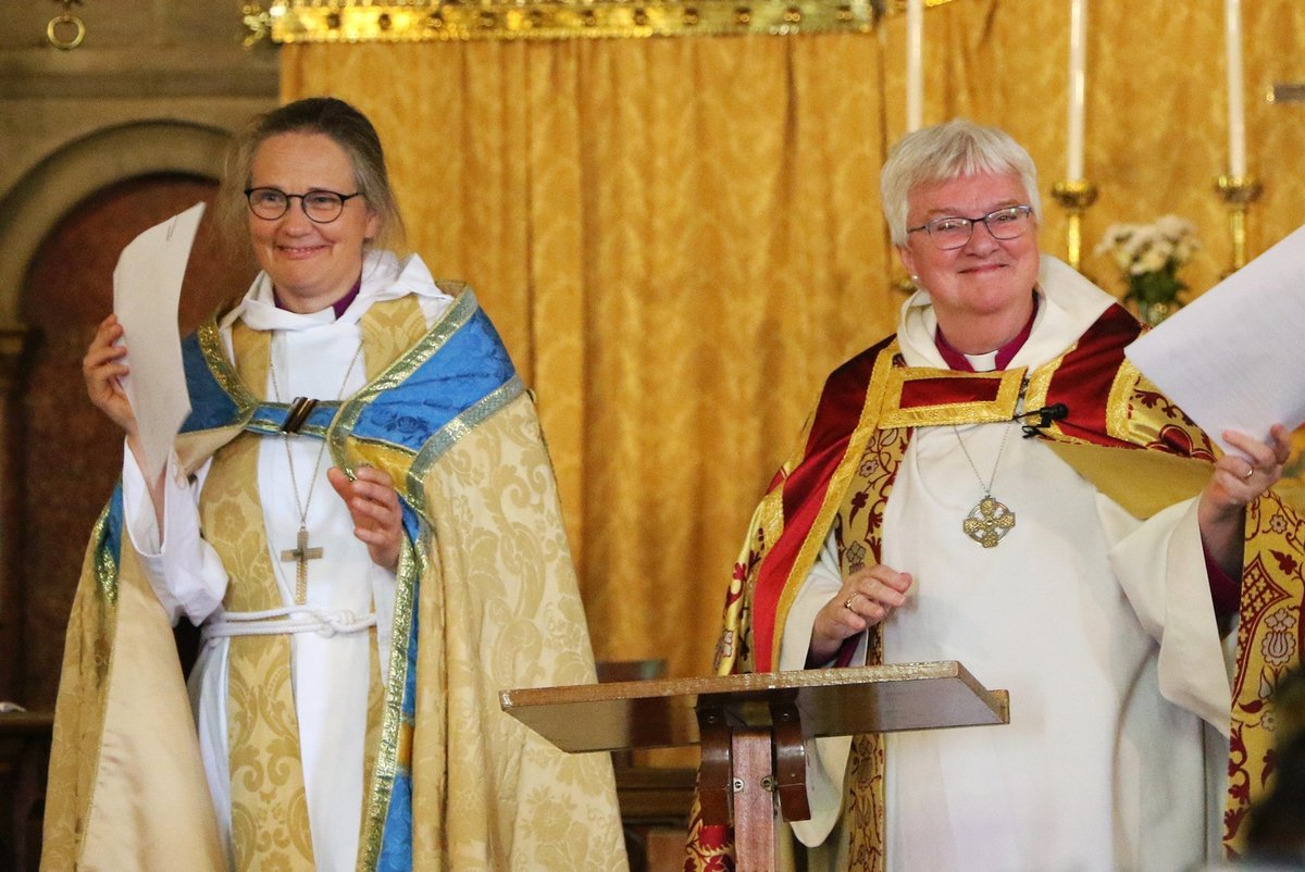 Bishop June and Bishop Karin signing a document