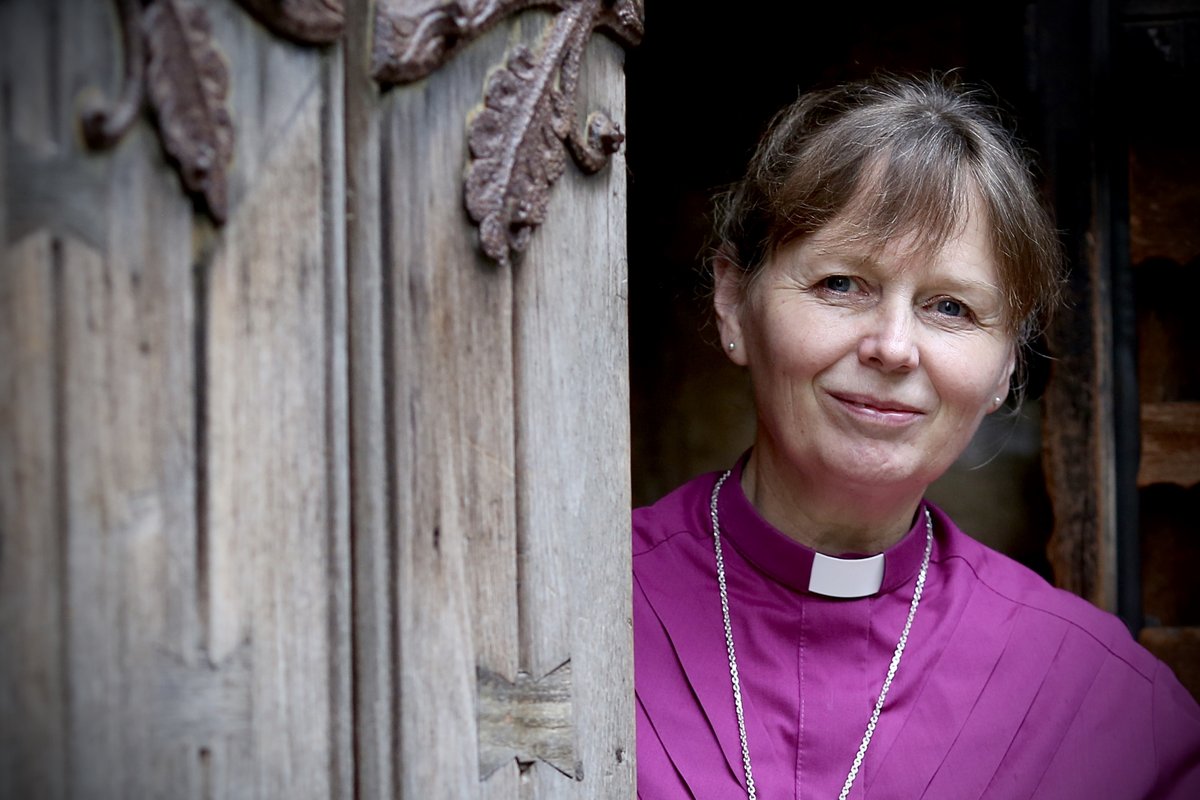 Bishop Mary smiling around the west door of Llandaff Cathedral