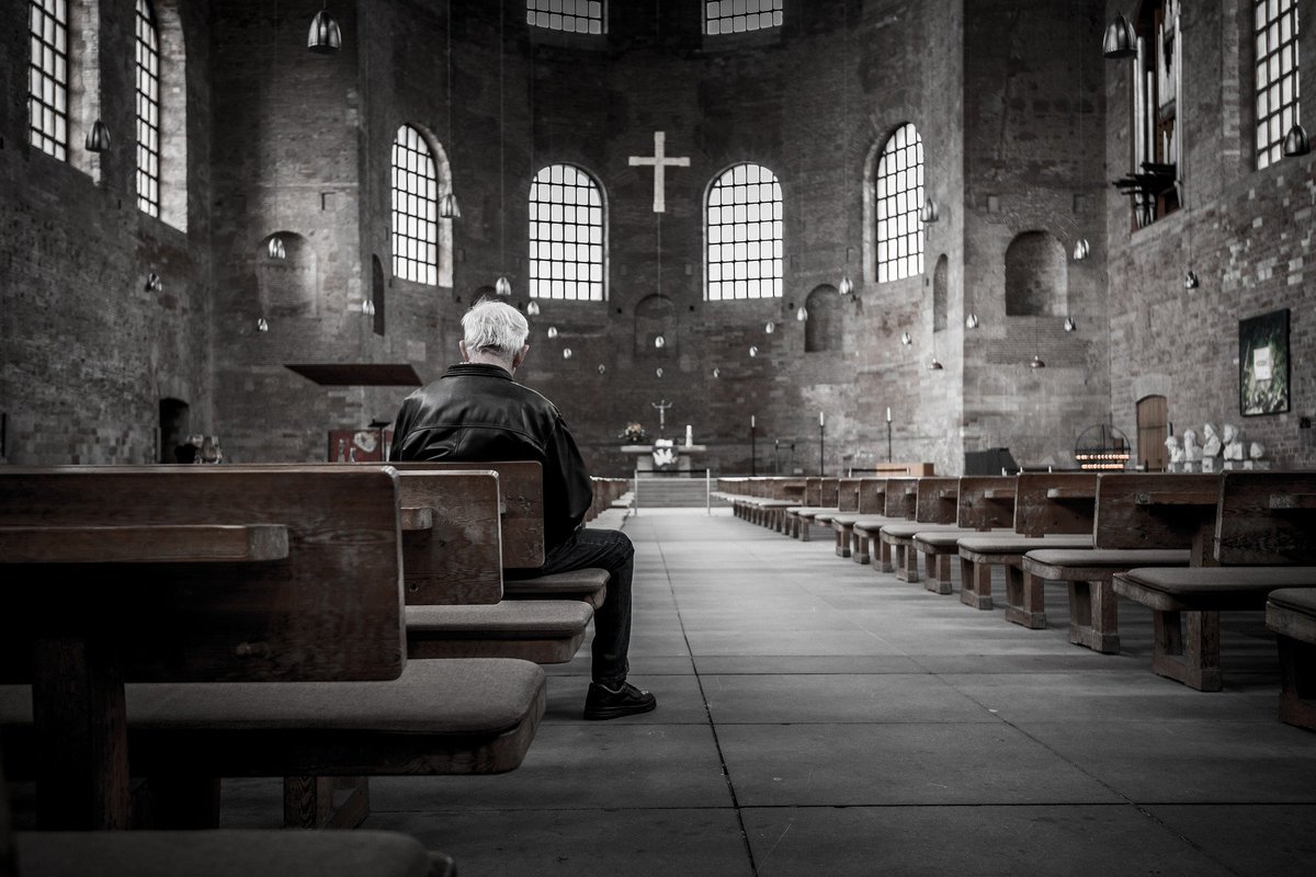 A man sitting alone in a dark church