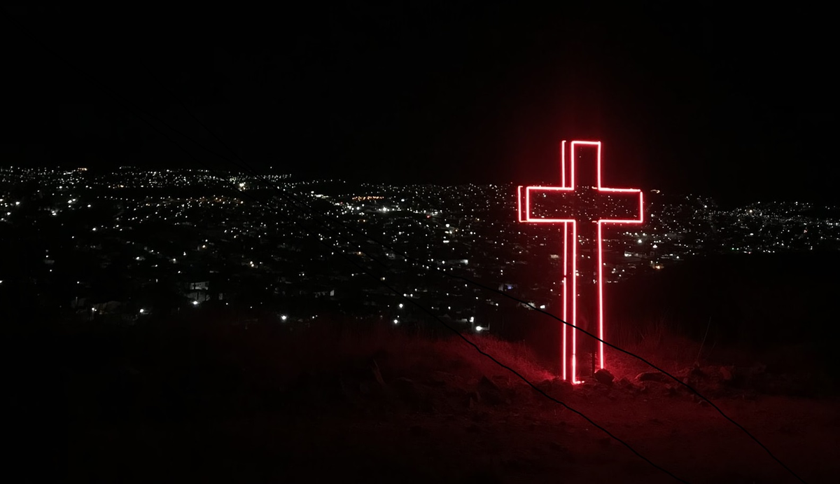 A cross over a city skyline